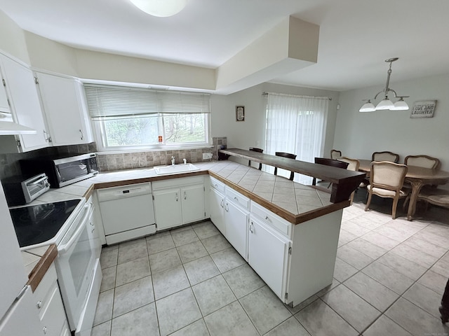 333 Vincellette St Unit 114, Bridgeport, CT 06606 - kitchen featuring white appliances, a peninsula, tile counters, and white cabinetry