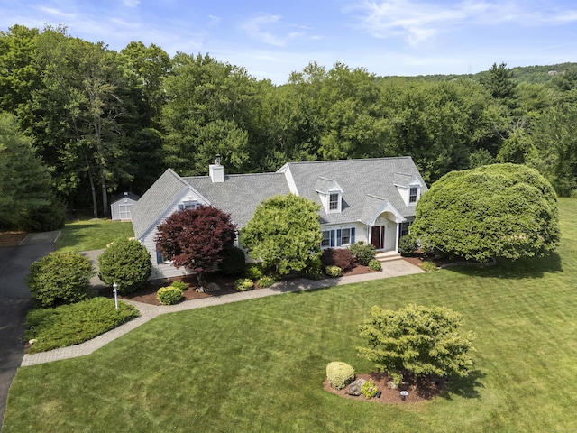 8 Marie Ln, Wallingford, CT 06492 - cape cod house featuring a front yard, a forest view, a storage shed, and a chimney