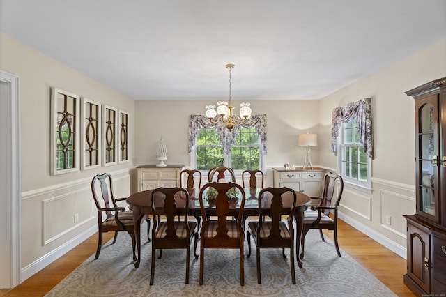 8 Marie Ln, Wallingford, CT 06492 - dining room featuring plenty of natural light, a chandelier, light wood-style flooring, a wainscoted wall, and a decorative wall