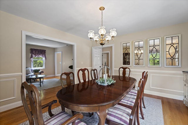 8 Marie Ln, Wallingford, CT 06492 - dining space with wood finished floors, a chandelier, a wainscoted wall, and a decorative wall