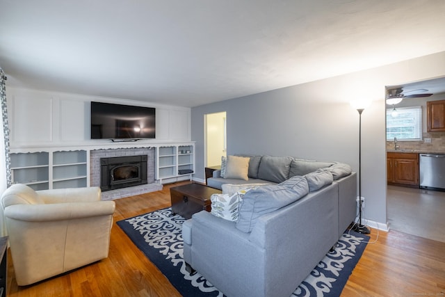 38 Evelyn Rd, Bristol, CT 06010 - living room with light wood-type flooring, ceiling fan, and a brick fireplace