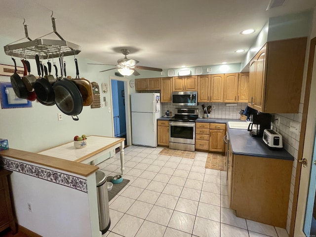 39 Mariner Cir, Trumbull, CT 06611 - kitchen featuring stainless steel appliances, tasteful backsplash, dark countertops, light tile patterned floors, and a ceiling fan