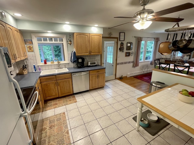 39 Mariner Cir, Trumbull, CT 06611 - kitchen with stainless steel dishwasher, baseboard heating, decorative backsplash, freestanding refrigerator, and recessed lighting