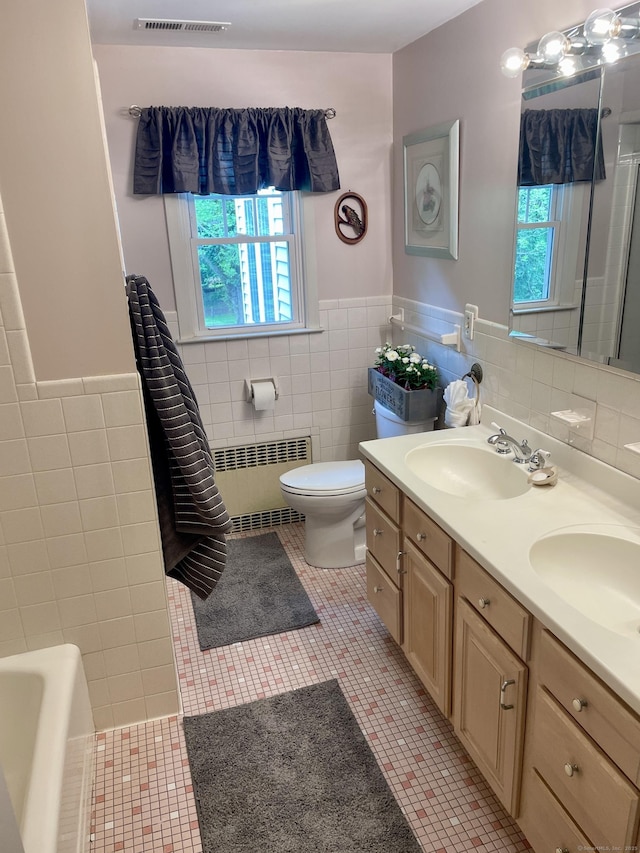 39 Mariner Cir, Trumbull, CT 06611 - bathroom with radiator, tile walls, plenty of natural light, double vanity, and tile patterned floors