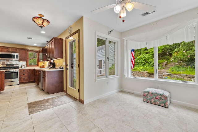 12 Haas Rd, Somers, CT 06071 - kitchen featuring stainless steel appliances, light countertops, light tile patterned floors, ceiling fan, and decorative backsplash