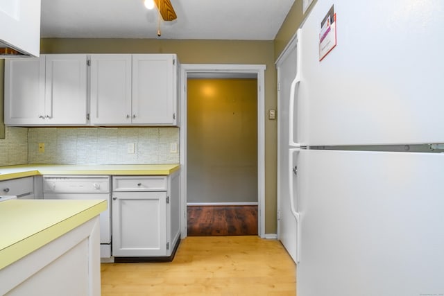 65 Heritage Vlg Unit B, Southbury, CT 06488 - kitchen featuring white appliances, light wood-type flooring, tasteful backsplash, light countertops, and white cabinetry