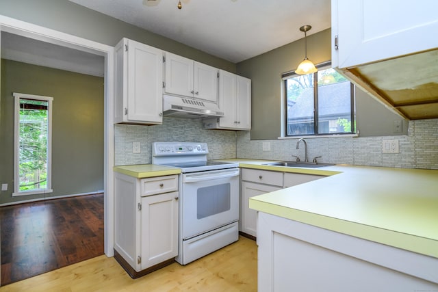 65 Heritage Vlg Unit B, Southbury, CT 06488 - kitchen featuring white electric range oven, under cabinet range hood, light wood-style flooring, and light countertops