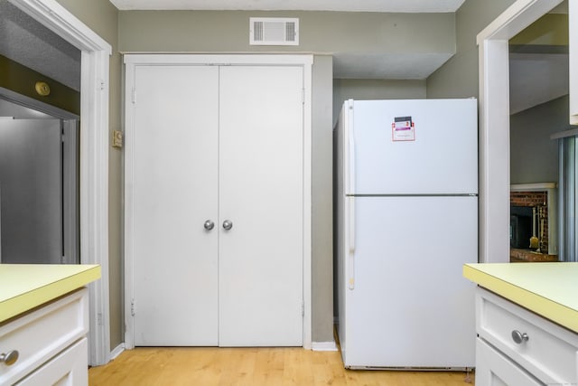 65 Heritage Vlg Unit B, Southbury, CT 06488 - kitchen with freestanding refrigerator, light countertops, and light wood-style floors