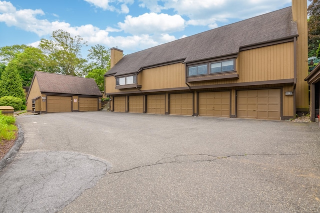 65 Heritage Vlg Unit B, Southbury, CT 06488 - view of front of home featuring community garages, a chimney, and a shingled roof