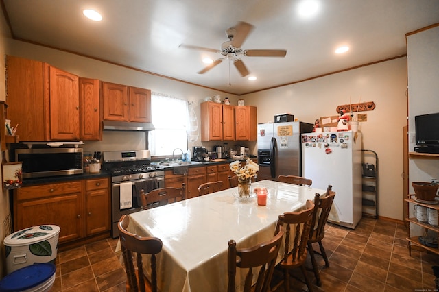 90 Olive St, Bridgeport, CT 06605 - kitchen with appliances with stainless steel finishes, under cabinet range hood, a ceiling fan, brown cabinets, and dark countertops