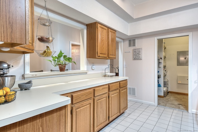 33 Langdon Ct Apt Cl4, Berlin, CT 06037 - kitchen featuring electric panel, light countertops, light tile patterned floors, and brown cabinets