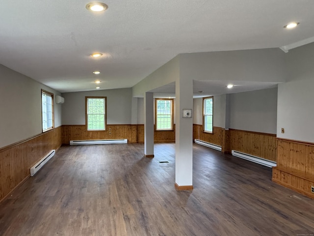 491 Main St, Somers, CT 06071 - unfurnished room with a baseboard radiator, a wainscoted wall, dark wood finished floors, wooden walls, and vaulted ceiling