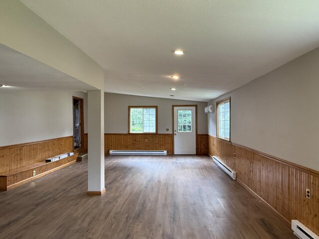 491 Main St, Somers, CT 06071 - unfurnished living room featuring a wainscoted wall, a baseboard heating unit, baseboard heating, wood walls, and wood finished floors