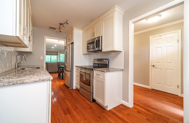 19 Heather Ct Unit 19, Cromwell, CT 06416 - kitchen with stainless steel appliances, white cabinets, light wood-style floors, decorative backsplash, and ornamental molding