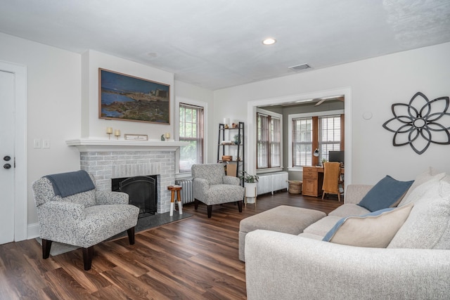 67 Nott St, Wethersfield, CT 06109 - living area with radiator, dark wood-style flooring, a brick fireplace, and recessed lighting