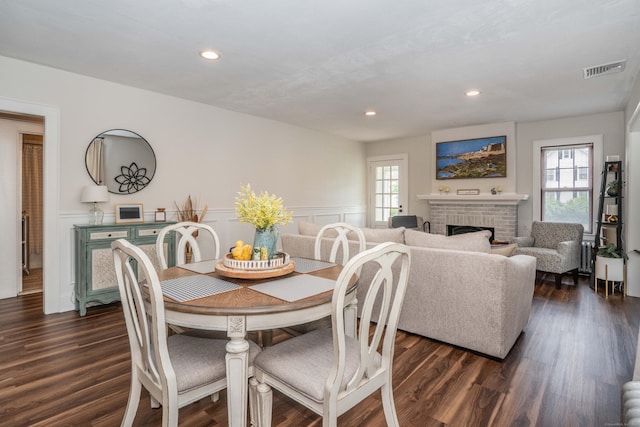 67 Nott St, Wethersfield, CT 06109 - dining room with healthy amount of natural light, a brick fireplace, dark wood finished floors, recessed lighting, and a wainscoted wall