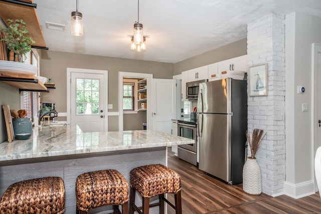 67 Nott St, Wethersfield, CT 06109 - kitchen with stainless steel appliances, dark wood-style flooring, open shelves, light stone counters, and a peninsula