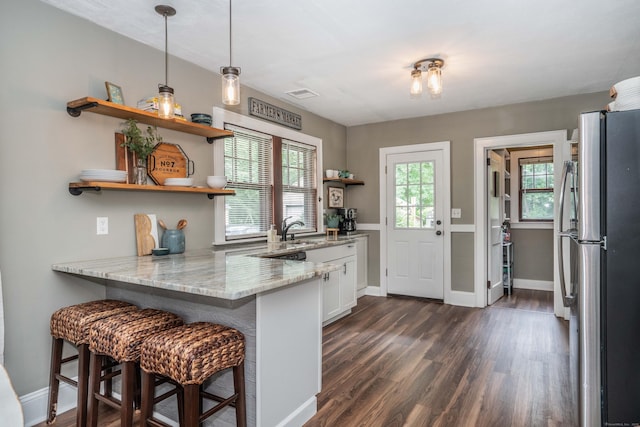 67 Nott St, Wethersfield, CT 06109 - kitchen with freestanding refrigerator, open shelves, white cabinets, dark wood finished floors, and a peninsula