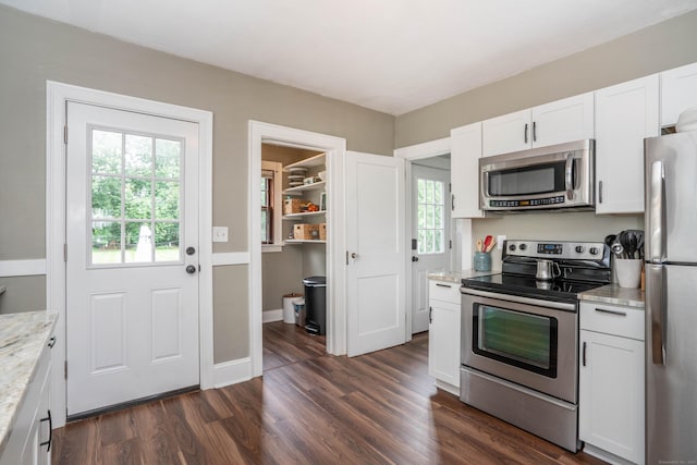 67 Nott St, Wethersfield, CT 06109 - kitchen with appliances with stainless steel finishes, white cabinetry, light stone counters, and dark wood-type flooring