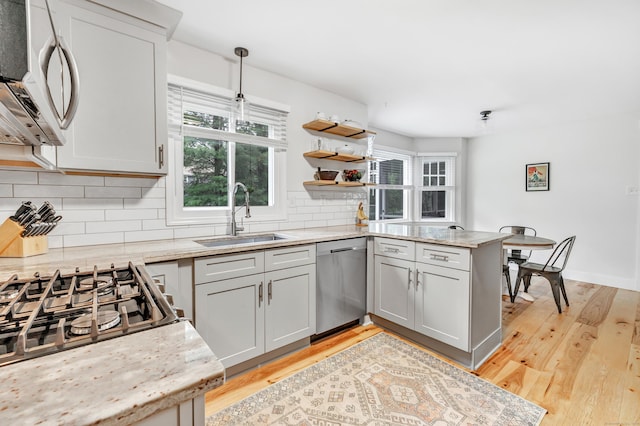31 Stable Ridge Rd, Monroe, CT 06468 - kitchen featuring appliances with stainless steel finishes, a peninsula, backsplash, light wood-style floors, and pendant lighting