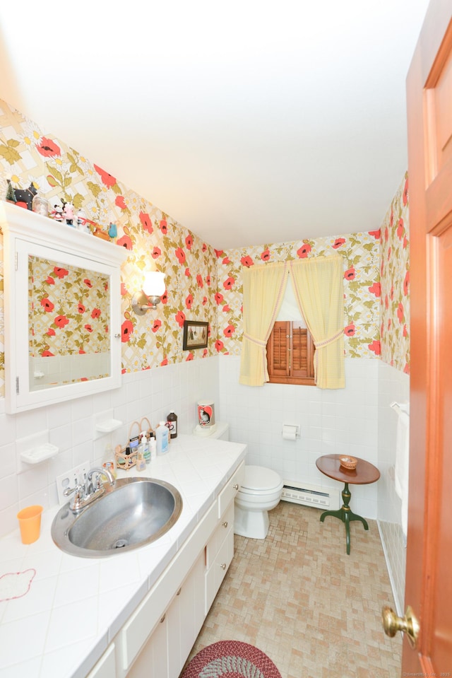 110 Woodfield Rd, Bristol, CT 06010 - bathroom with wallpapered walls, tile walls, baseboard heating, a wainscoted wall, and vanity
