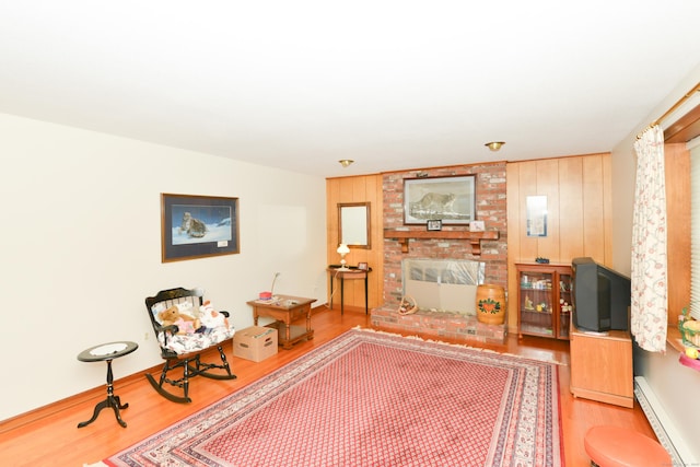 110 Woodfield Rd, Bristol, CT 06010 - living room with wood finished floors, a brick fireplace, and a baseboard radiator