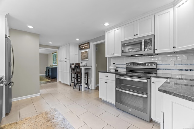 109 Hemlock Dr, Killingworth, CT 06419 - kitchen with stainless steel appliances, recessed lighting, white cabinets, backsplash, and light tile patterned floors