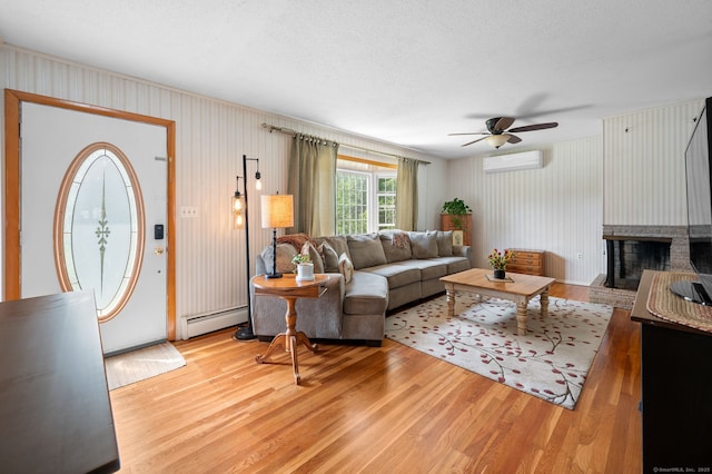 43 Dimmock Rd, Waterford, CT 06385 - living room featuring a baseboard radiator, ceiling fan, light wood finished floors, a wall mounted air conditioner, and a fireplace