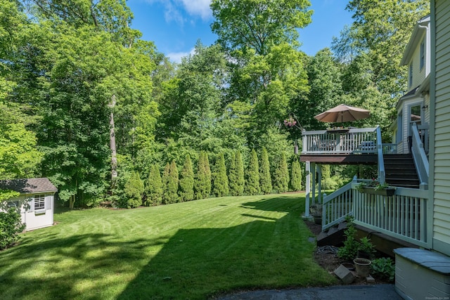 10 Oak Dr, Essex, CT 06409 - view of green lawn with stairway, a wooden deck, and an outdoor structure