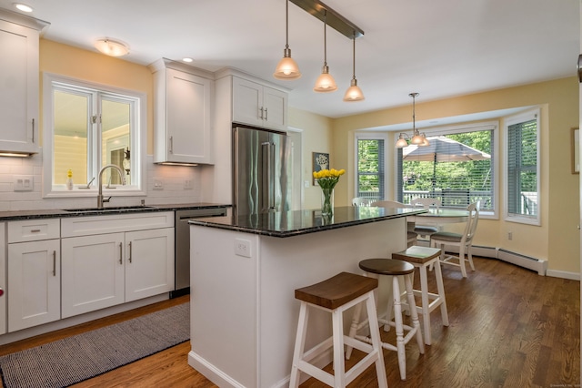 10 Oak Dr, Essex, CT 06409 - kitchen with appliances with stainless steel finishes, a baseboard radiator, dark wood-style floors, decorative backsplash, and recessed lighting