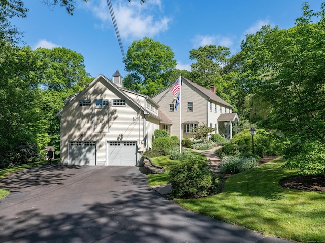 10 Oak Dr, Essex, CT 06409 - view of property exterior featuring driveway, an attached garage, a chimney, and a yard