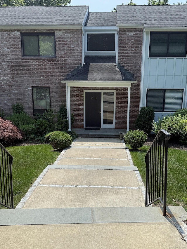 13 Hills Ln Unit 13, Norwalk, CT 06880 - view of exterior entry with brick siding, a shingled roof, and board and batten siding