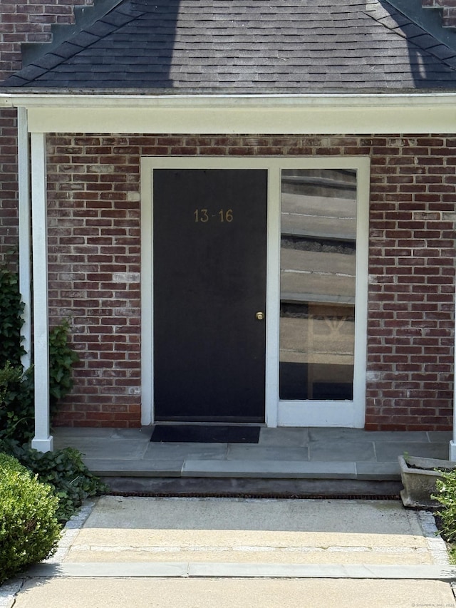 13 Hills Ln Unit 13, Norwalk, CT 06880 - view of exterior entry with roof with shingles and brick siding