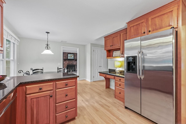 30 Clifdon Dr, Simsbury, CT 06070 - kitchen featuring stainless steel fridge, light wood finished floors, a brick fireplace, decorative light fixtures, and brown cabinetry