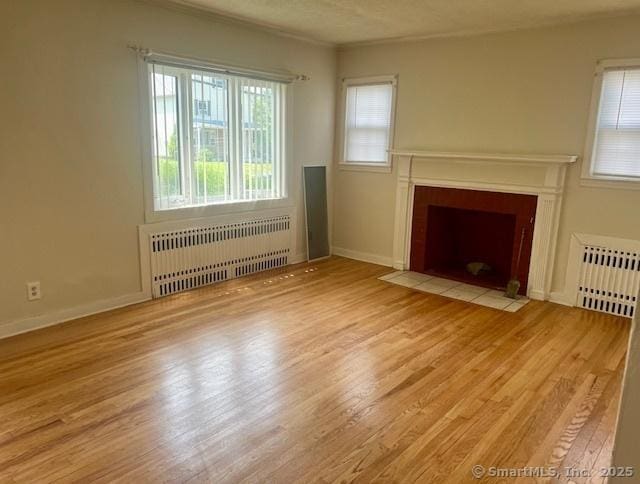 489 Adams St, Manchester, CT 06040 - unfurnished living room with radiator, wood finished floors, a fireplace with flush hearth, and ornamental molding