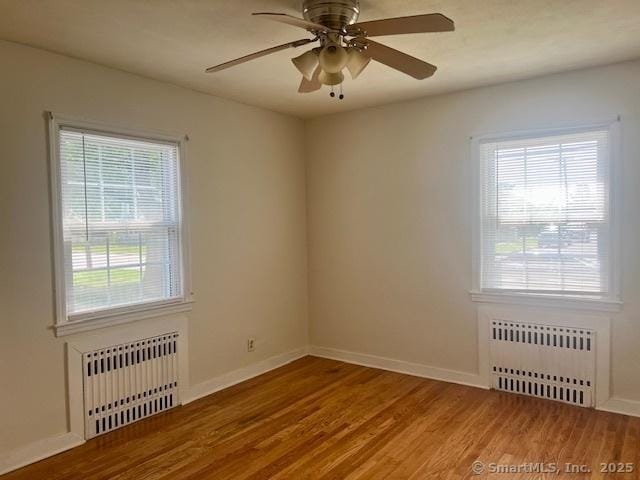 489 Adams St, Manchester, CT 06040 - unfurnished room with radiator heating unit, wood finished floors, and healthy amount of natural light