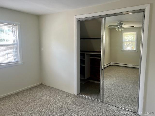 489 Adams St, Manchester, CT 06040 - unfurnished bedroom featuring a closet, a baseboard radiator, multiple windows, and carpet floors