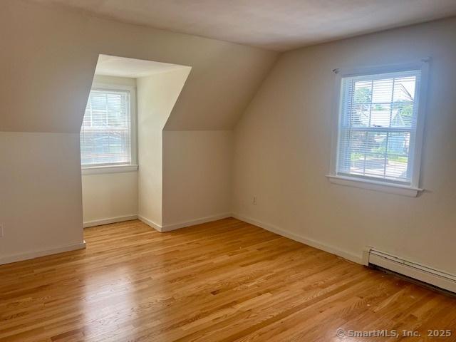 489 Adams St, Manchester, CT 06040 - additional living space featuring a baseboard radiator, light wood-type flooring, and lofted ceiling