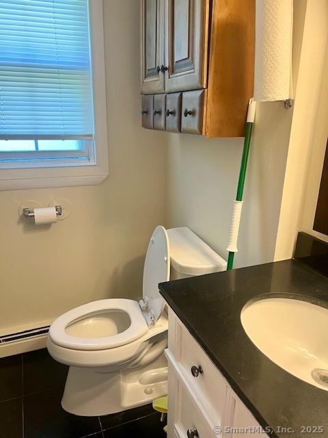 489 Adams St, Manchester, CT 06040 - half bathroom featuring vanity, a baseboard heating unit, and tile patterned floors
