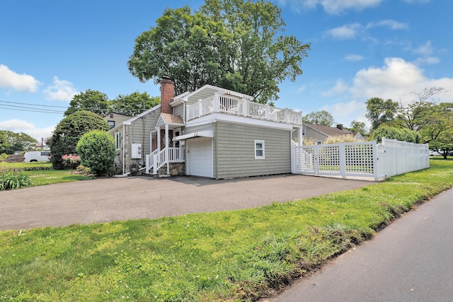 16 Senga Rd, Norwalk, CT 06854 - view of front of property featuring a balcony, a chimney, a garage, and asphalt driveway