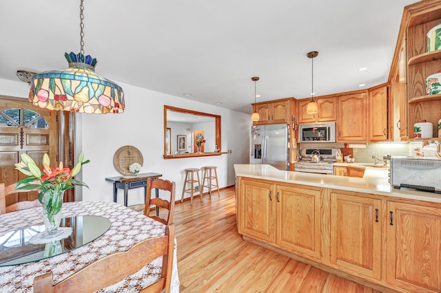 16 Senga Rd, Norwalk, CT 06854 - kitchen featuring appliances with stainless steel finishes, open shelves, light wood-type flooring, a peninsula, and tasteful backsplash
