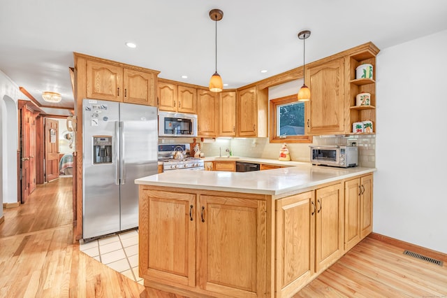 16 Senga Rd, Norwalk, CT 06854 - kitchen featuring appliances with stainless steel finishes, a peninsula, light countertops, tasteful backsplash, and light wood finished floors