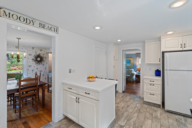 16 Lynde St, Old Saybrook, CT 06475 - kitchen featuring freestanding refrigerator, wallpapered walls, light wood finished floors, white cabinets, and light countertops