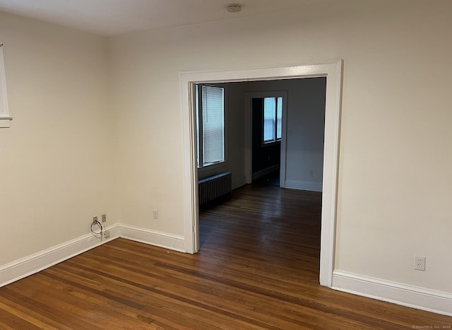 84 Love Ln, Hartford, CT 06112 - unfurnished room with radiator heating unit, dark wood-type flooring, and a smoke detector