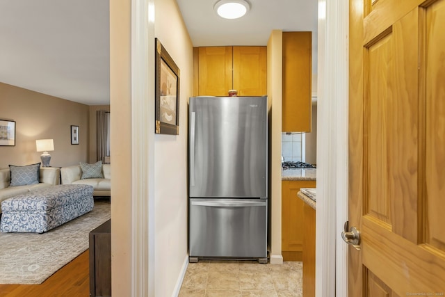50 Glenbrook Rd Apt 7C, Stamford, CT 06902 - kitchen with freestanding refrigerator, open floor plan, tasteful backsplash, and brown cabinetry