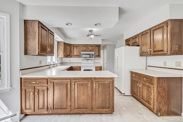 90 Chamberlain Dr, Shelton, CT 06484 - kitchen featuring white appliances, a baseboard heating unit, light countertops, brown cabinetry, and a peninsula