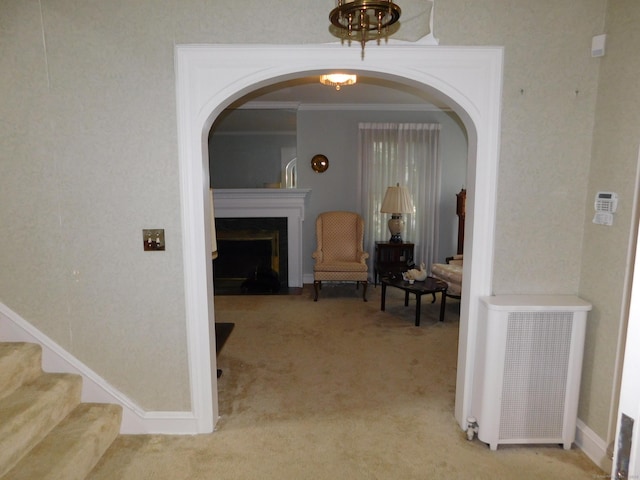 58 Edward St, East Haven, CT 06512 - hallway featuring light carpet, ornamental molding, stairs, a chandelier, and arched walkways