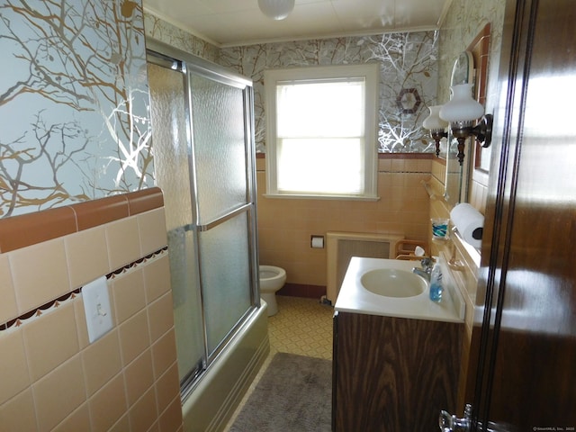 58 Edward St, East Haven, CT 06512 - bathroom featuring tile walls, radiator heating unit, vanity, a wainscoted wall, and enclosed tub / shower combo