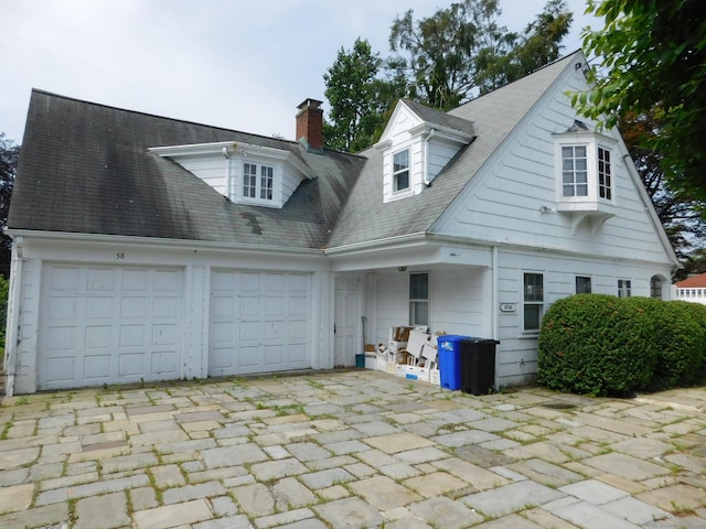 58 Edward St, East Haven, CT 06512 - view of front of house featuring a garage, driveway, and a chimney