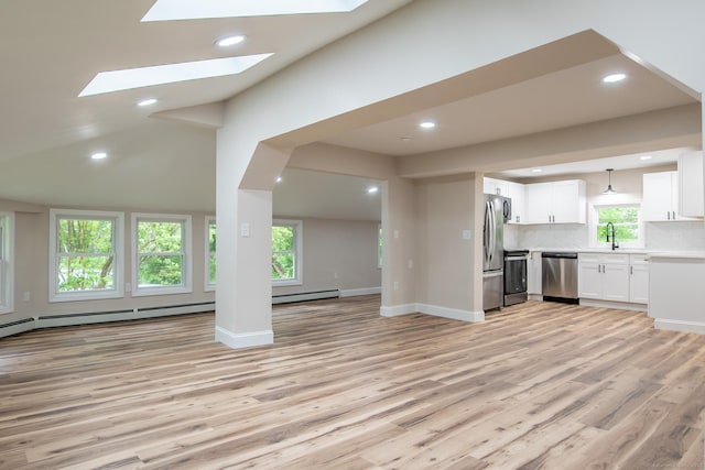 859 Ekonk Hill Rd, Voluntown, CT 06384 - unfurnished living room with light wood-style flooring, recessed lighting, plenty of natural light, baseboard heating, and a skylight